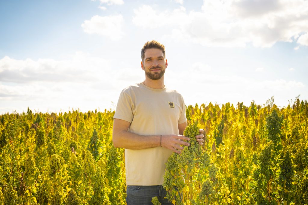 Mudda Natur johannes mit quinoadolde im feld front lächelnd